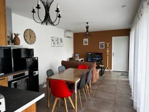 une salle à manger avec une table et des chaises rouges dans l'établissement Maison La capucine sur Quai de Seine, wifi, machine à laver, parking privé gratuit, à Vernon