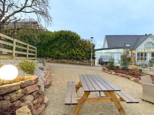 una mesa de picnic de madera sentada en medio de un patio en Retraite nature - Maison 150 m2 avec parking privé, balcon, brasero & ping-pong, en Gingsheim