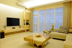 a living room with a couch and a tv at Buenos Garden Home Stay in Dayin