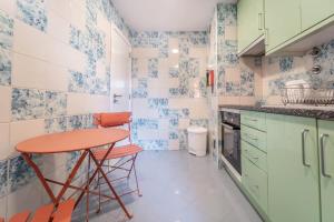 eine kleine Küche mit blauen und weißen Fliesen in der Unterkunft Al Marina View Uma - Lux apartment on the marina in Páteo