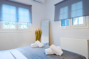 Noho Villas @ Sunlit house Paros في Nea Cryssi Akti: غرفة نوم مع سرير مع وسادتين بيضاء