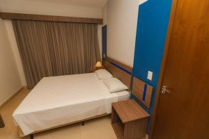 a small room with a bed and a wooden door at Alta Vista Thermas - OFICIAL in Caldas Novas +41 photos