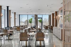 a restaurant with tables and chairs and large windows at GRANO HOTEL Solmarina in Wiślinka