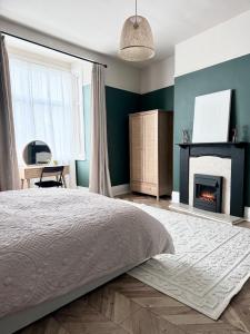 a bedroom with a bed and a fireplace at Boho Bay Two - Seaside Escape in Cullercoats