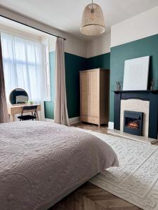 a bedroom with a bed and a fireplace at Boho Bay Two - Seaside Escape in Cullercoats +24 photos
