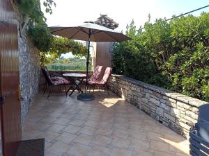 a patio with a table and chairs and an umbrella at HEDRA in Zambratija