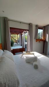 a bedroom with two white beds and a window at Casa da Bella - 1,5km do centro de Lumiar in Nova Friburgo