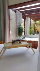 a table with a potted plant on top of a bed at Casa da Bella - 1,5km do centro de Lumiar in Nova Friburgo