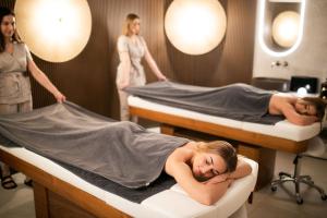 two girls are laying on beds in a hospital at GRANO HOTEL Solmarina in Wiślinka