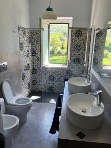 a bathroom with two sinks and a toilet at L'Oasi della Fonte in Albanella