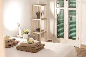 Un dormitorio con una cama blanca con toallas. en Queen Regina Suites, en Nicosia