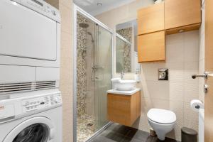 a bathroom with a washing machine and a sink at City Comfort Apartments in Reykjavík +32 photos