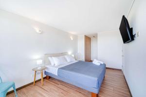 una camera da letto con un letto e una TV a schermo piatto di Oceana Suite - Frente al Mar a Concón Altre 21 foto