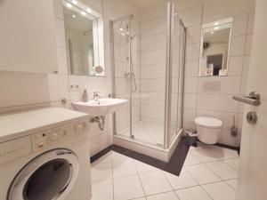 蒂门多弗施特兰德Obj 69 - FeWO Strandläufer 2- bis 4 Personen inkl Strandkorb Top Lage 90 m zum Strand的带淋浴水槽和洗衣机的浴室 更多9张照片