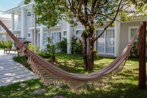 una hamaca frente a una casa en Flamingo - 4 suite -15 gasten - Arraial d' Ajuda, en Porto Seguro