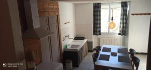 a small kitchen with a table and a sink at Vogüé Meublé 2 étoiles, Un écrin de beauté et de nature in Vogüé +18 photos