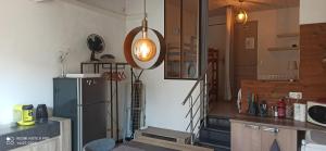 a kitchen with a refrigerator and stairs in a room at Vogüé Meublé 2 étoiles, Un écrin de beauté et de nature in Vogüé