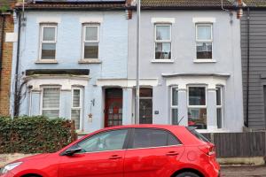 a red car parked in front of a house at Ivy on Sea Villa in Southend-on-Sea