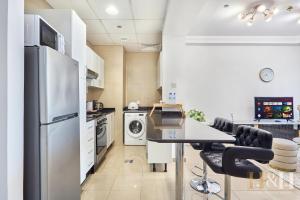 una cucina con frigorifero e tavolo con sedie di Dubai Marina Sea View Sunset View Dubai Eye View a Dubai