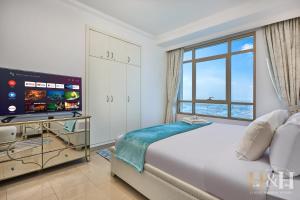 una camera da letto con un letto grande e una televisione di Dubai Marina Sea View Sunset View Dubai Eye View a Dubai