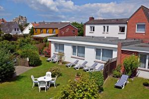 een tuin met stoelen en een tafel en een huis bij Haus Thorwarth - Hotel garni in Cuxhaven