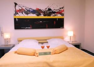 a bedroom with a bed with two glasses on it at Studio Deluxe in Weil am Rhein