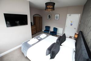 a bedroom with two beds and a flat screen tv at OYO Glyn Valley Hotel in Llansantffraid Glyn Ceiriog +31 photos