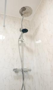 a shower with a shower head in a bathroom at Modern 2 bed Bromley House in Grove Park +28 photos