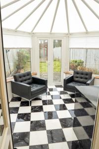 a conservatory with a black and white checkered floor at Modern 2 bed Bromley House in Grove Park
