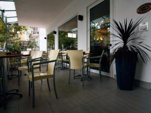 a restaurant with chairs and a table and a potted plant at Hotel Marebello in Rimini