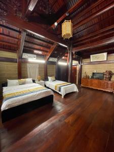 a bedroom with two beds in a room with wooden floors at Mộc Lan resort in Phu Quoc