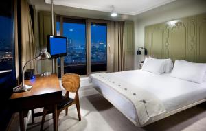 a bedroom with a bed and a desk with a computer at The Cettia Istanbul in Istanbul +54 photos