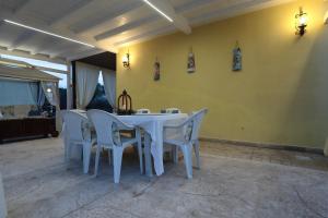 a dining room with a white table and chairs at Villa Biniritta in Villaggio San Leonardo +55 photos