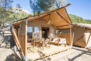 een tent met een tafel en stoelen op een terras bij Càmping Castell Montgrí **** in L'Estartit
