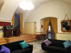 a living room with two couches and a piano at Hotel Trieste in Morbegno