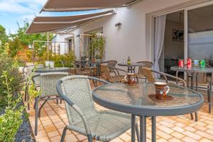 a patio with tables and chairs on a patio at les Alizés in Notre-Dame-de-Monts