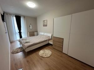 a bedroom with a bed and a dresser at SISI Apartment in Tirana