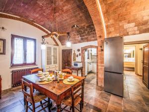 a kitchen and dining room with a table and a refrigerator at Holiday Home Villa Angiolino by Interhome in Poggibonsi
