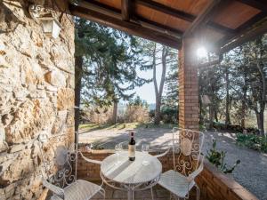a table and chairs on a patio with a bottle of wine at Holiday Home Villa Angiolino by Interhome in Poggibonsi
