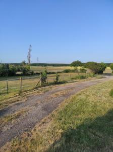 una strada sterrata in un campo con una recinzione di Studio dans les boucles de Seine proche de Rouen a Saint-Pierre-de-Manneville