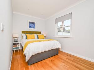 a white bedroom with a bed and a window at Holiday Home Sea Compass by Interhome in Charlestown