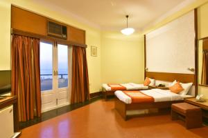 ムンバイにあるSea Green South Hotelのベッド2台とバルコニーが備わるホテルルームです。