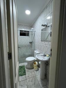 a bathroom with a toilet and a sink at Apartamento aconchegante na Praia do Pereque-Açu in Ubatuba