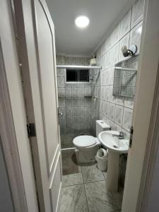 a small bathroom with a toilet and a sink at Apartamento aconchegante na Praia do Pereque-Açu in Ubatuba