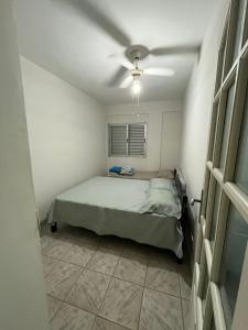 a bedroom with a bed and a ceiling fan at Apartamento aconchegante na Praia do Pereque-Açu in Ubatuba