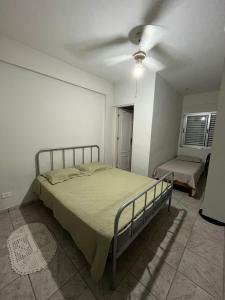 a bedroom with a bed and a ceiling fan at Apartamento aconchegante na Praia do Pereque-Açu in Ubatuba