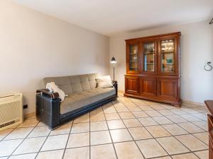 a living room with a couch and a tiled floor at Holiday Home Maison Valandon by Interhome in Coursan