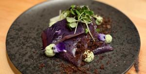 a black plate with a piece of food on it at Nivunki Village in Muonio