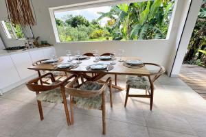 Una mesa de comedor con sillas y una ventana. en Villa The Grey House, en Grand-Bourg