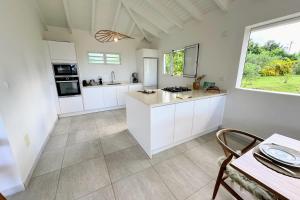 Una cocina con gabinetes blancos y una ventana grande. en Villa The Grey House, en Grand-Bourg 12 fotos más